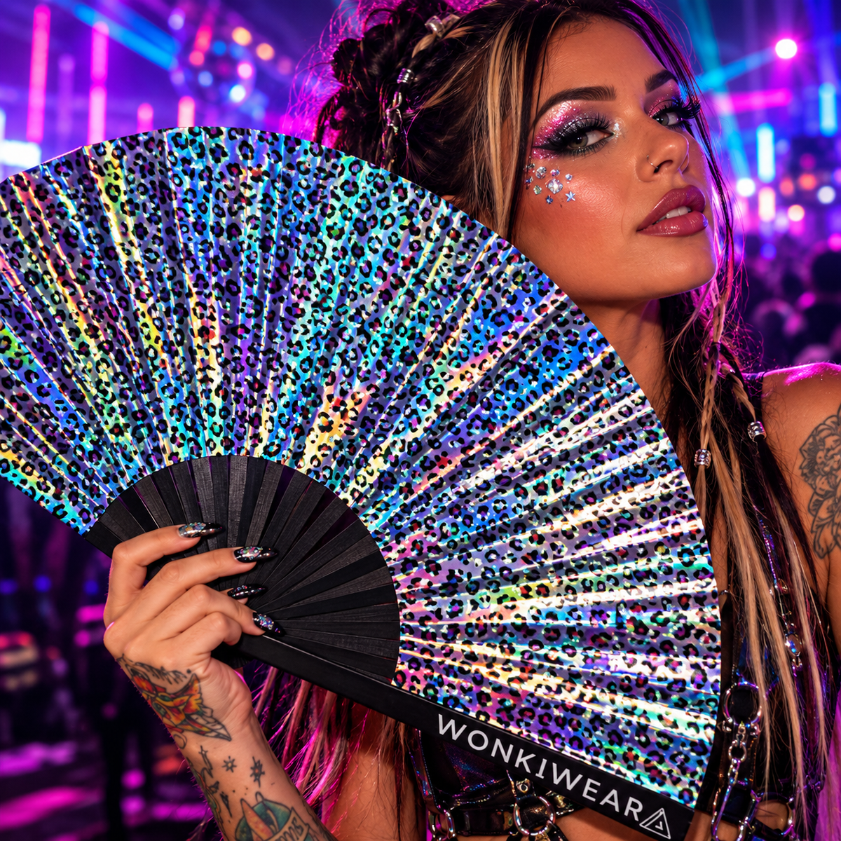 Woman holding a rainbow leopard print iridescent festival fan at a neon rave