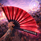 Red iridescent rave fan reflecting light at a music festival crowd