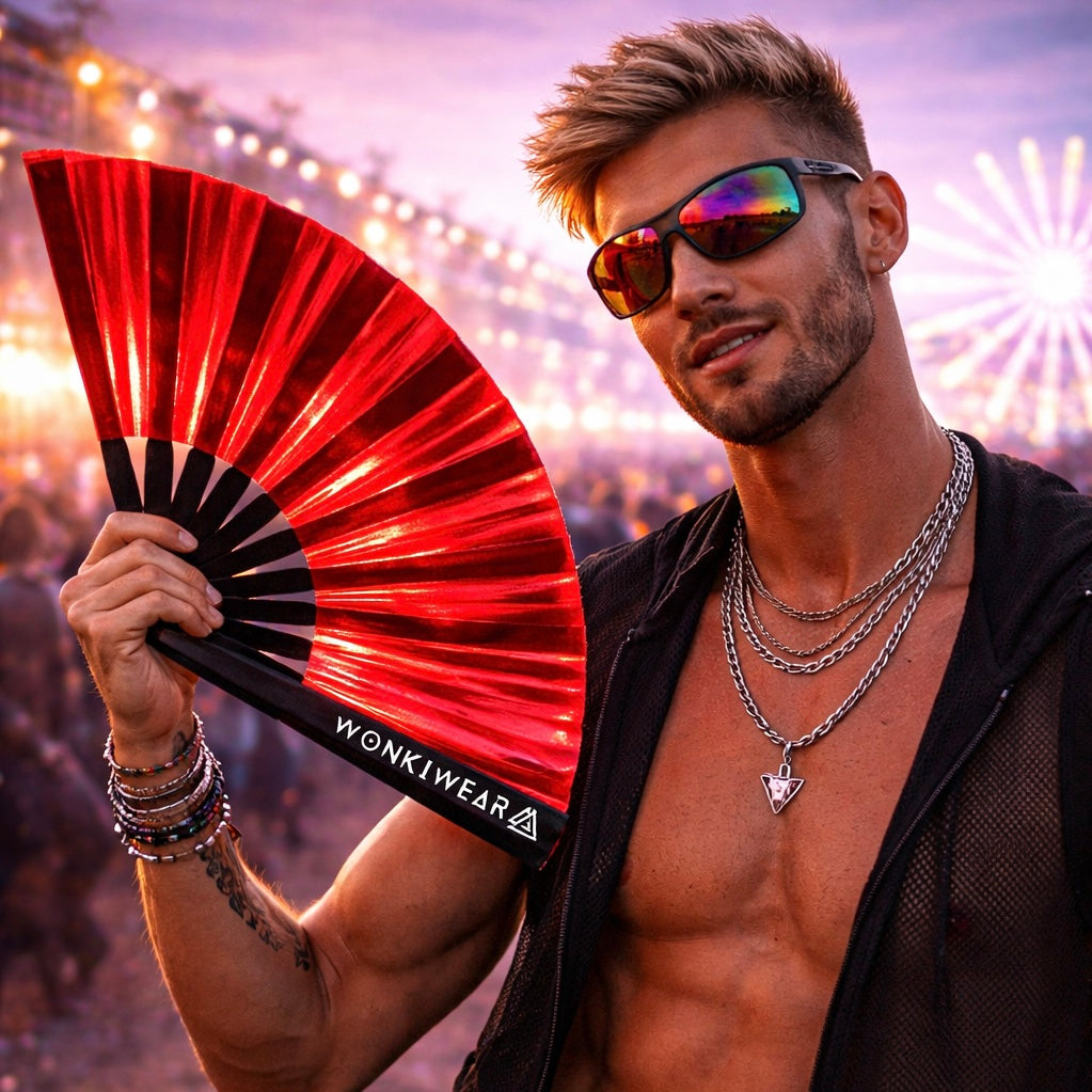 Man holding red iridescent rave fan at festival wearing sunglasses