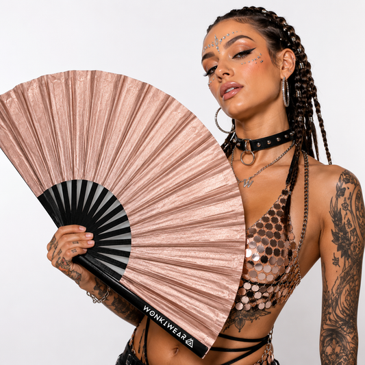 Festival model holding XL rose gold shimmer metallic festival fan during studio photoshoot