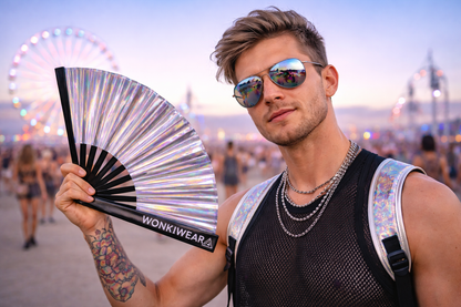 Man holding silver iridescent rave fan at music festival wearing sunglasses