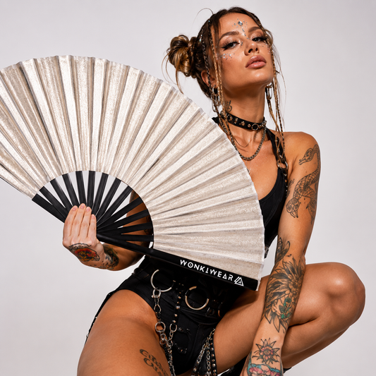 Festival model holding XL silver shimmer metallic festival fan in studio photoshoot