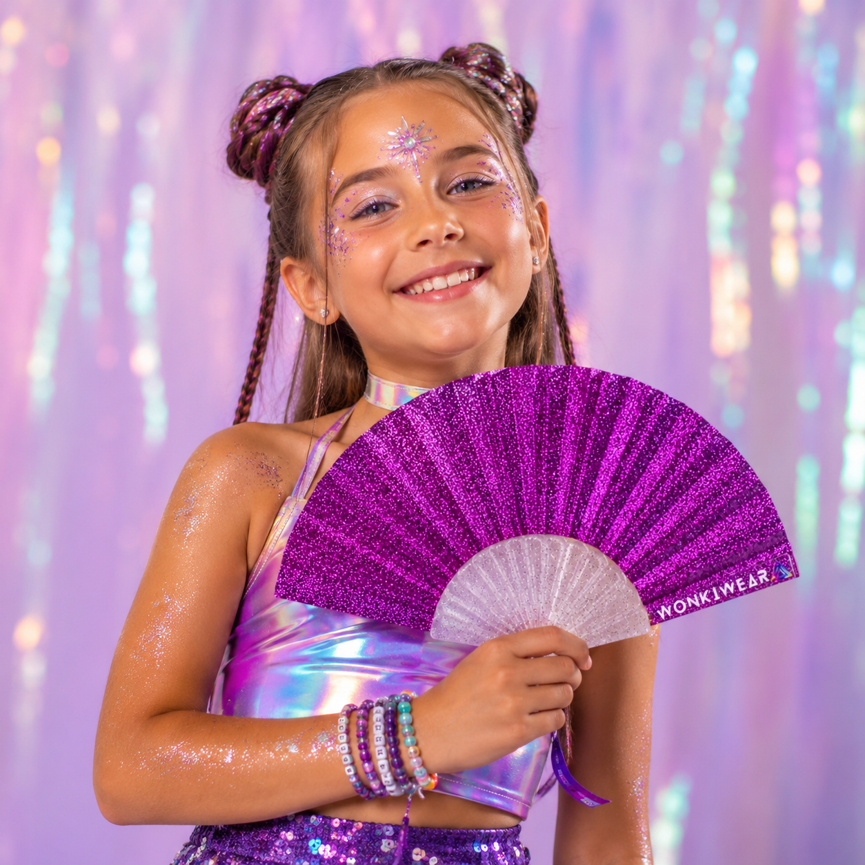 Child using bright pink glitter folding fan at outdoor festival