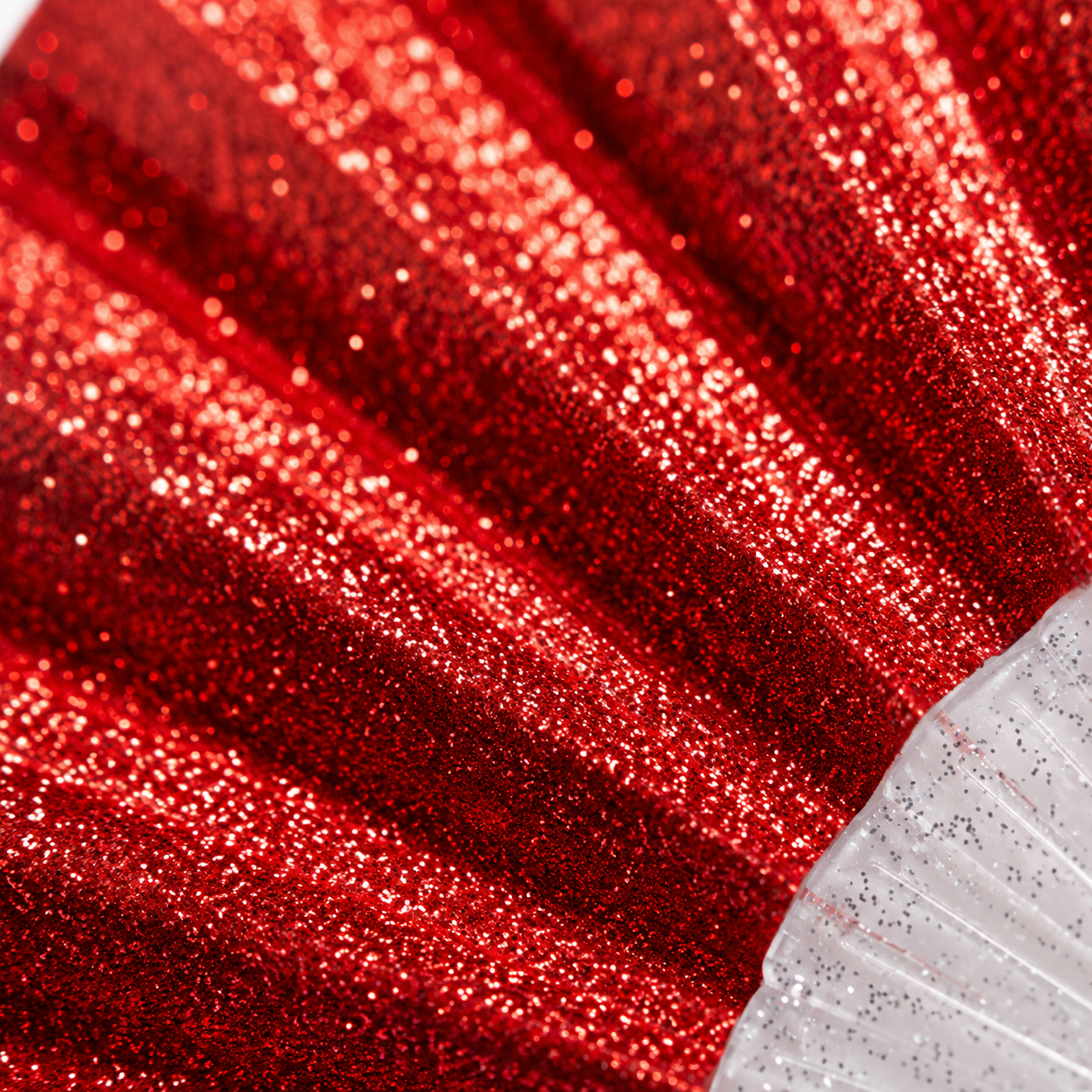 Macro close-up of red glitter fabric showing sparkling texture detail