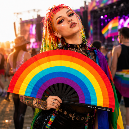 Festival goer using Spectrum Rainbow XL folding fan at an outdoor music festival