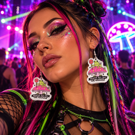 Woman wearing frog and mushroom “Negative Self-Talk Not Allowed” statement earrings at a colourful neon rave