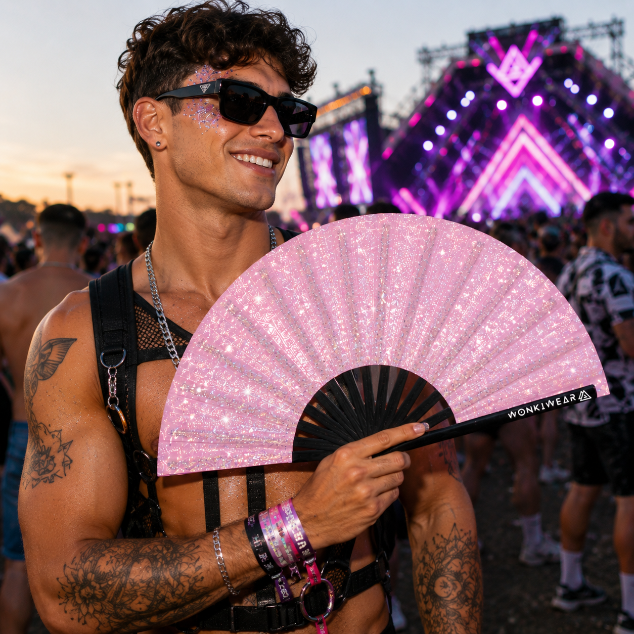 Male festival goer holding pink glitter XL festival fan