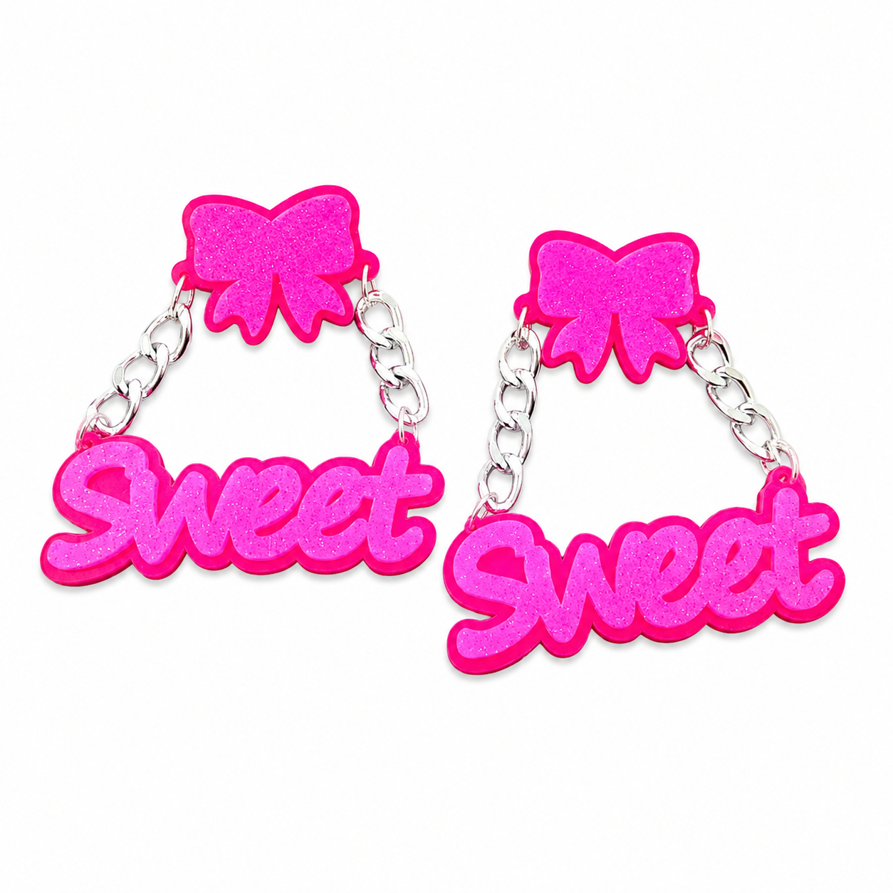 Oversized neon pink SWEET statement earrings with bow tops on white background