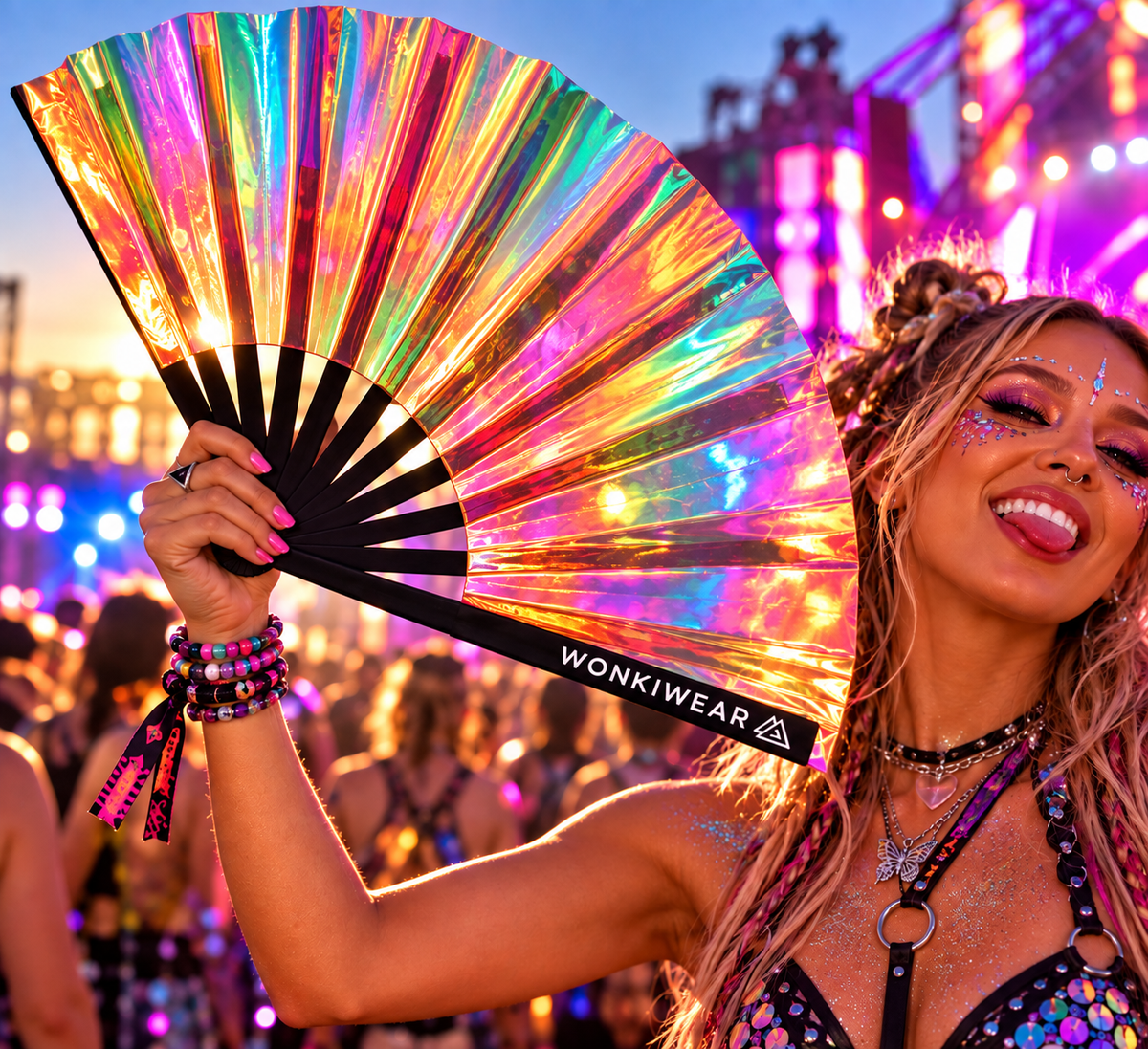 Iridescent rainbow festival fan with a semi-transparent holographic finish held by a woman at a colourful outdoor rave.