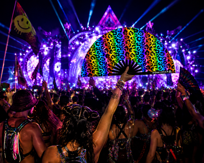 UV reactive rainbow leopard print festival fan glowing in rave crowd