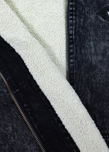 Close-up showing the cream sherpa lining beside the black acid-wash denim outer