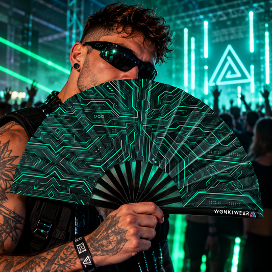 Man dancing at an underground techno rave holding a black folding fan with teal Cyber Circuit graphics and WonkiWear branding.