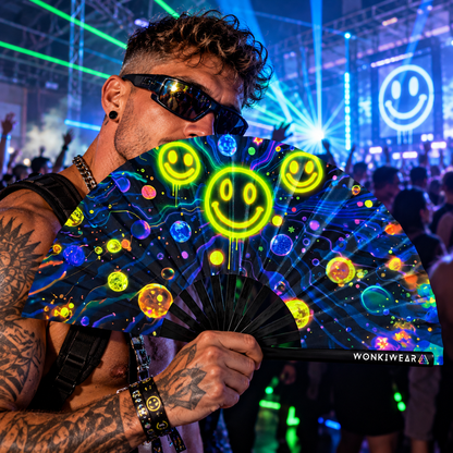 Male techno raver holding a WonkiWear galaxy smiley folding fan at a neon-lit UK rave.