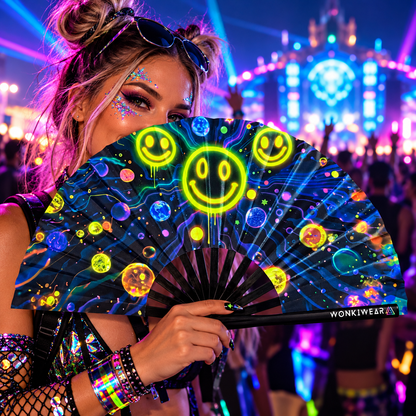 WonkiWear galaxy smiley face folding fan held by a festivalgoer at a neon-lit rave.