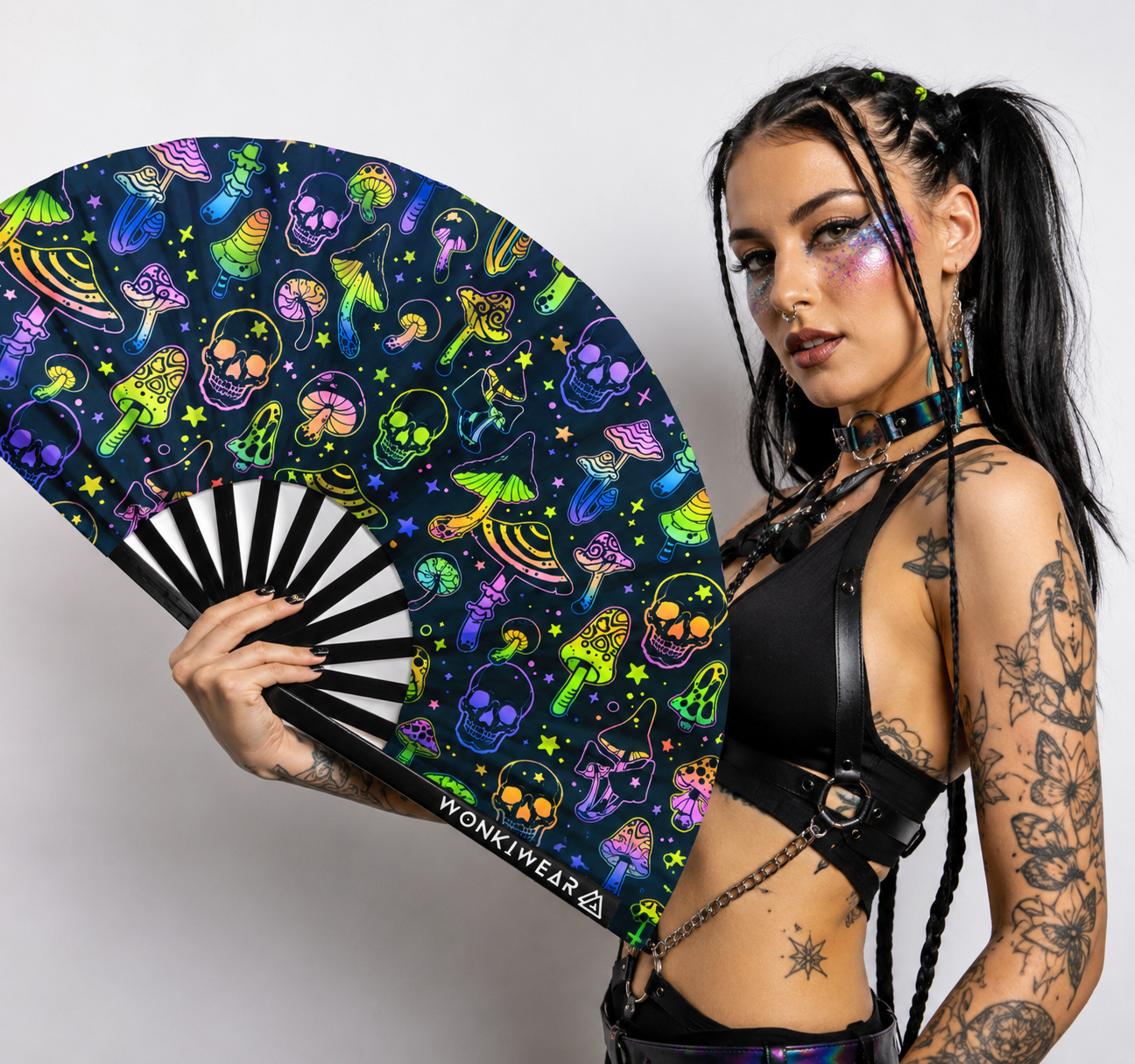 Female festival model holding XL UV reactive mushroom and skulls rave fan