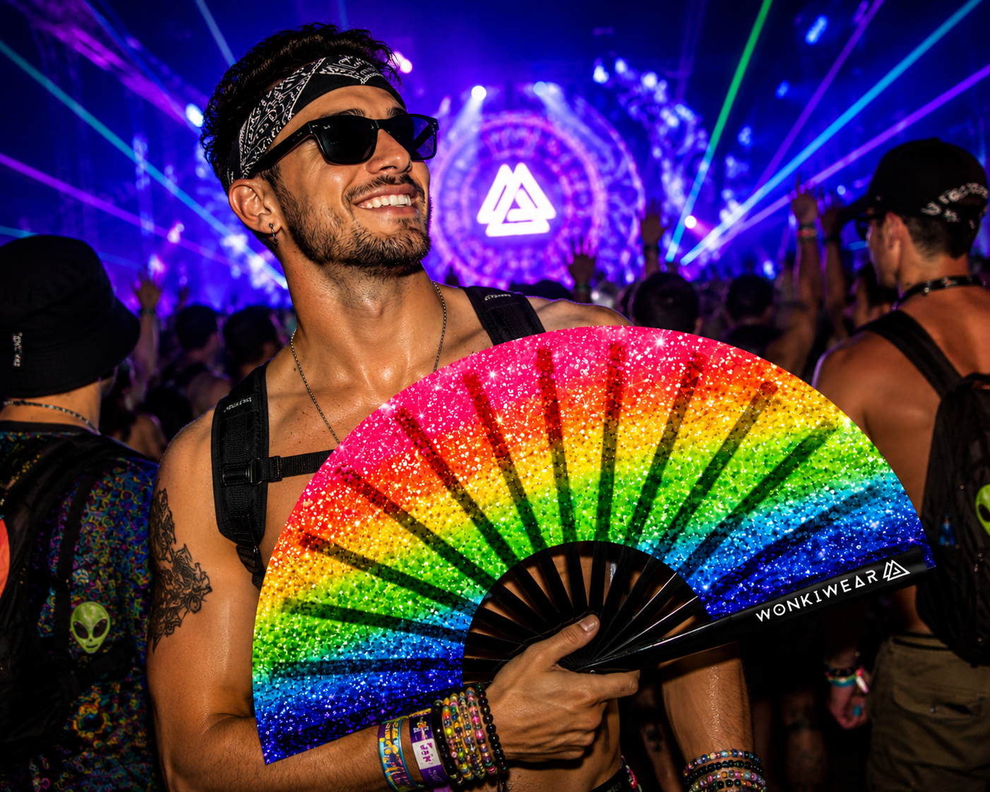 Male festival model holding XL rainbow Pride printed glitter effect rave fan