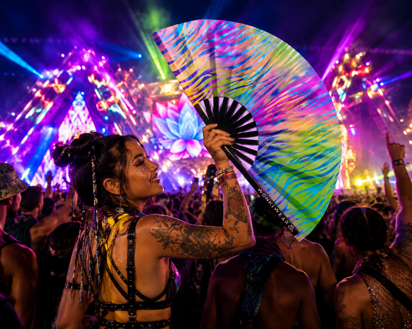 Festival crowd dancing with pastel zebra UV reactive rave fan under colourful lighting