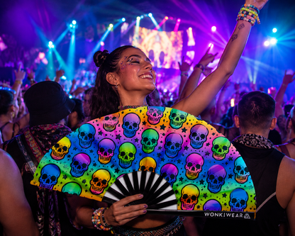 Festival crowd using XL UV reactive skull rave fan at nightclub or festival