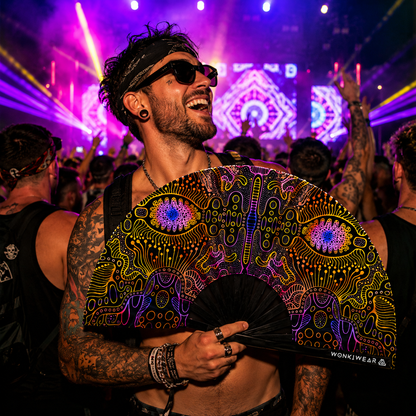 Festival crowd with UV reactive techno psytrance rave fan under neon event lighting