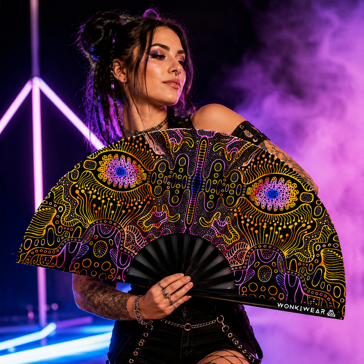 Female festival model holding XL UV reactive techno psytrance rave fan