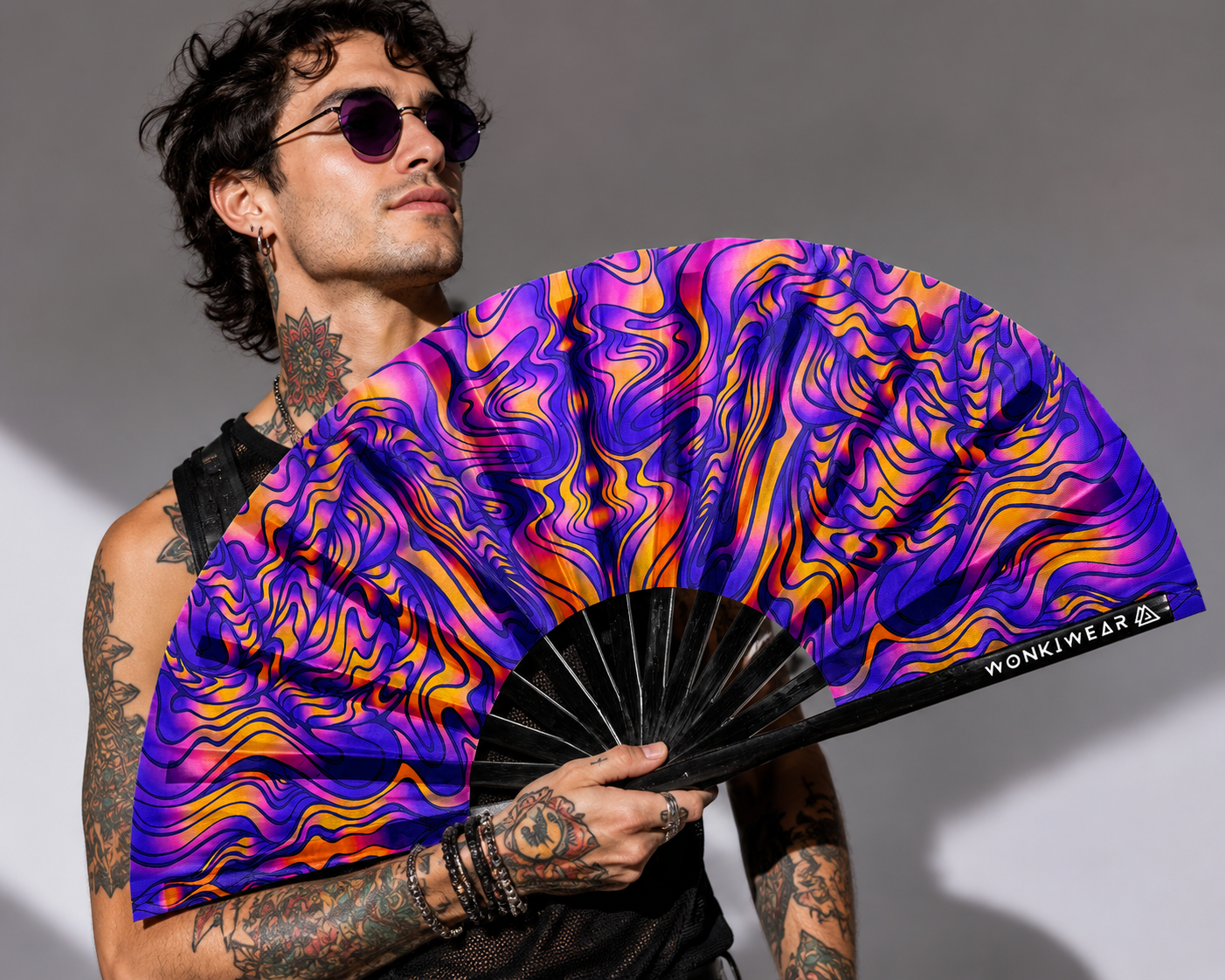 Male festival model holding XL UV reactive trippy orange blue rave fan