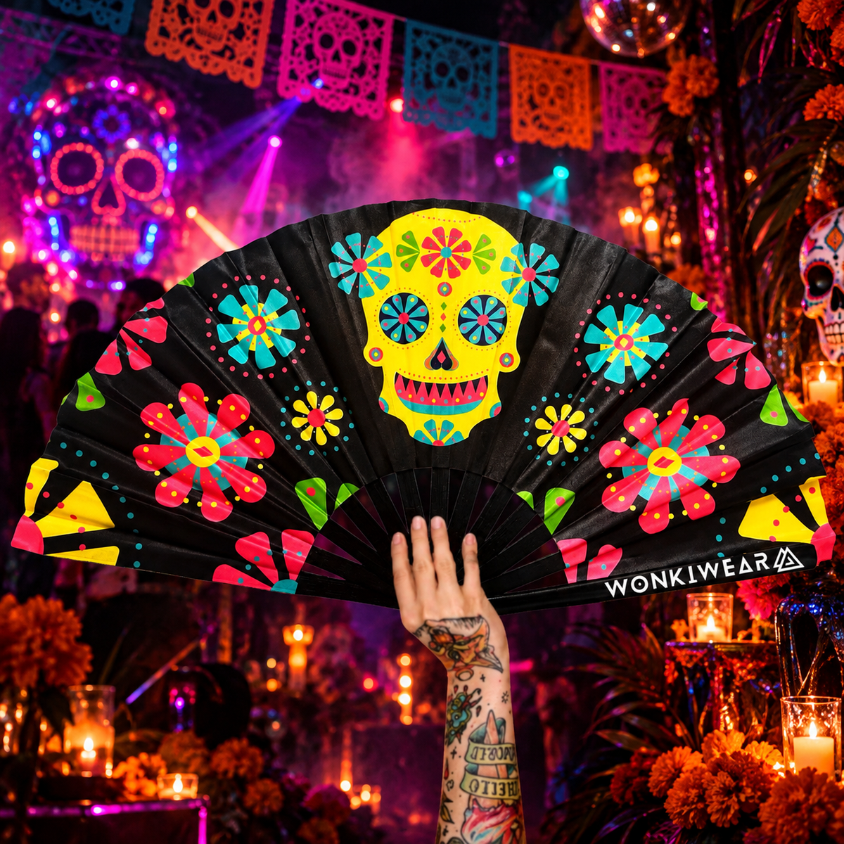 XL sugar skull folding fan with colourful floral design and WonkiWear branding at a neon Day of the Dead rave