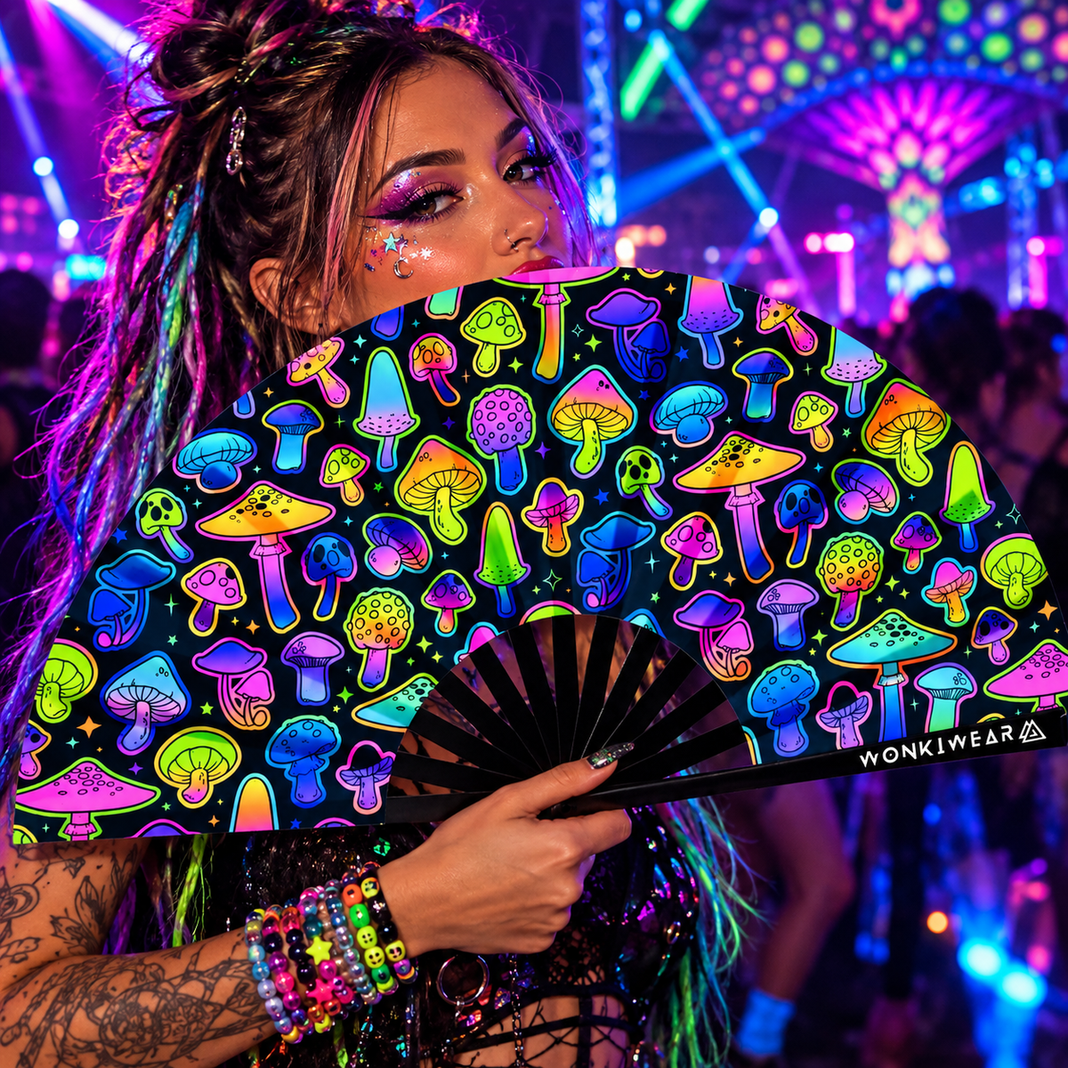 Woman holding an XL UV reactive mushroom festival fan at a neon rave